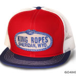 A red, blue, and white cap with king ropes label