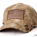 A brown patterned tactical camo cap with flag