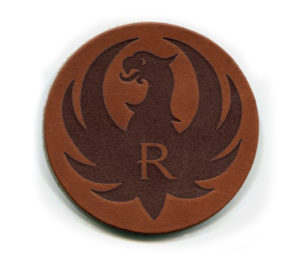A leather coaster with the letter r on it.