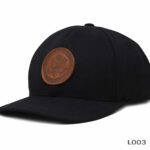 Black cap with brown leather emblem.