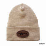 Beige beanie with brown oval patch.